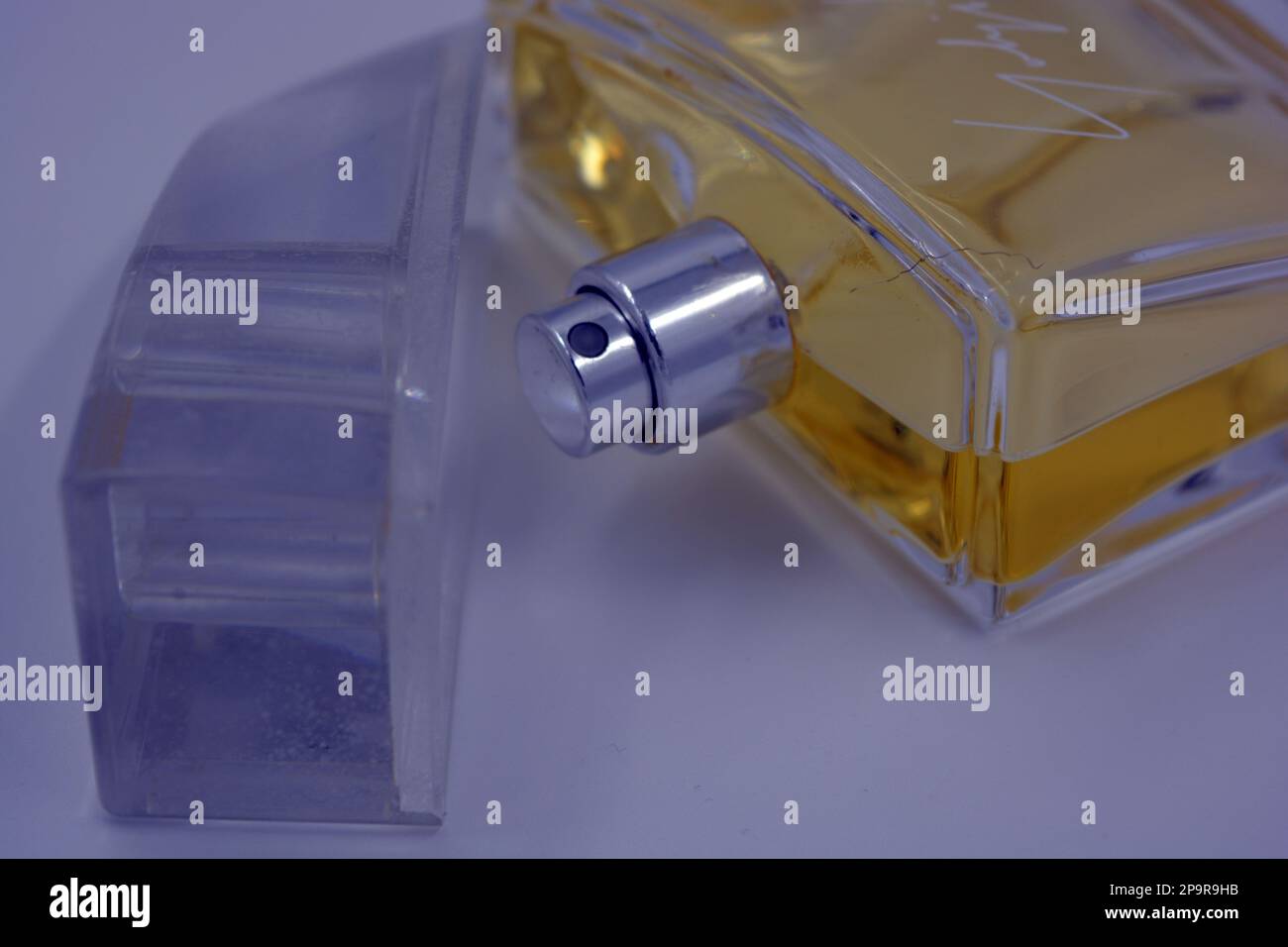 Profumo elegante da donna, una bottiglia di profumo in una bottiglia di vetro con un fresco aroma luminoso e liquido giallo si trova su uno sfondo bianco. Foto Stock