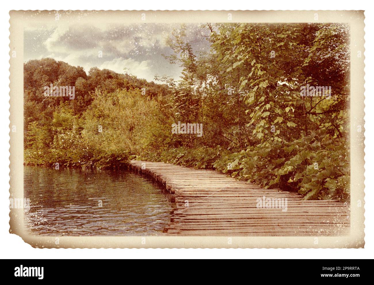 Vecchia foto di carta. Ponte in legno sul fiume e splendida vista sulla foresta Foto Stock