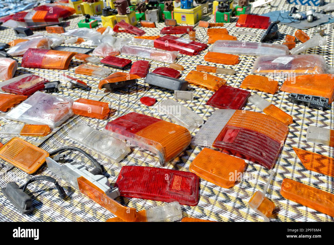 Assortimento polveroso di ricambi per auto da collezione sparsi sul terreno per la vendita Foto Stock