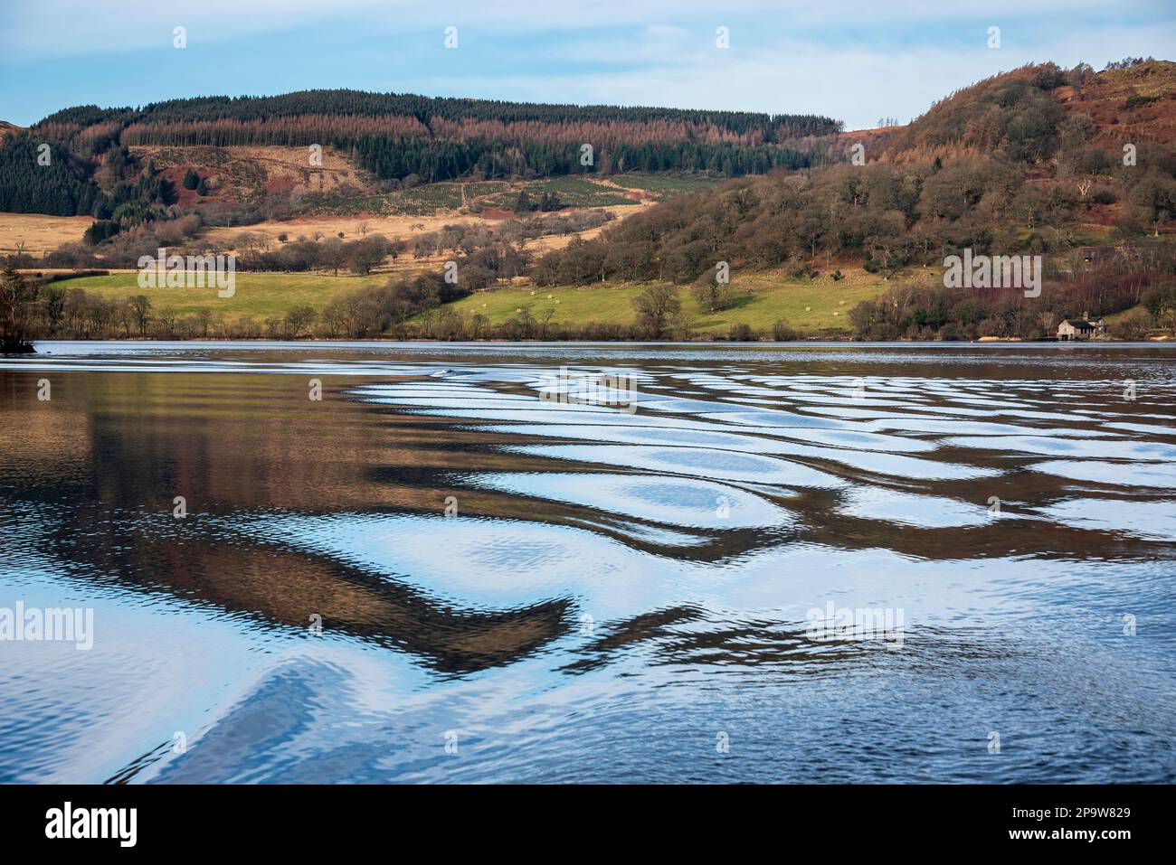 Bella immagine del paesaggio invernale vista dalla barca su Ullswater nel Lake District con insoliti movimenti di ondulazione dell'acqua Foto Stock