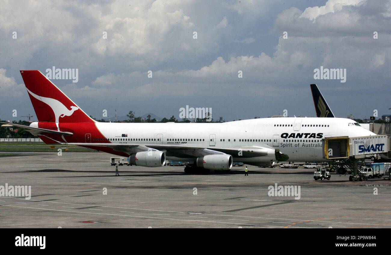 A Qantas Airways Boeing 747-400 passenger plane sits on the tarmac of the Ninoy Aquino International Airport following an emergency Friday July 25, 2008 in Manila, Philippines, with damage to its right wing fuselage. The plane, with 350 passengers and 19 crew, was enroute to Australia from London when a loud bang punched a hole in the right wing fuselage, passengers said. (AP Photo/Bullit Marquez) Foto Stock