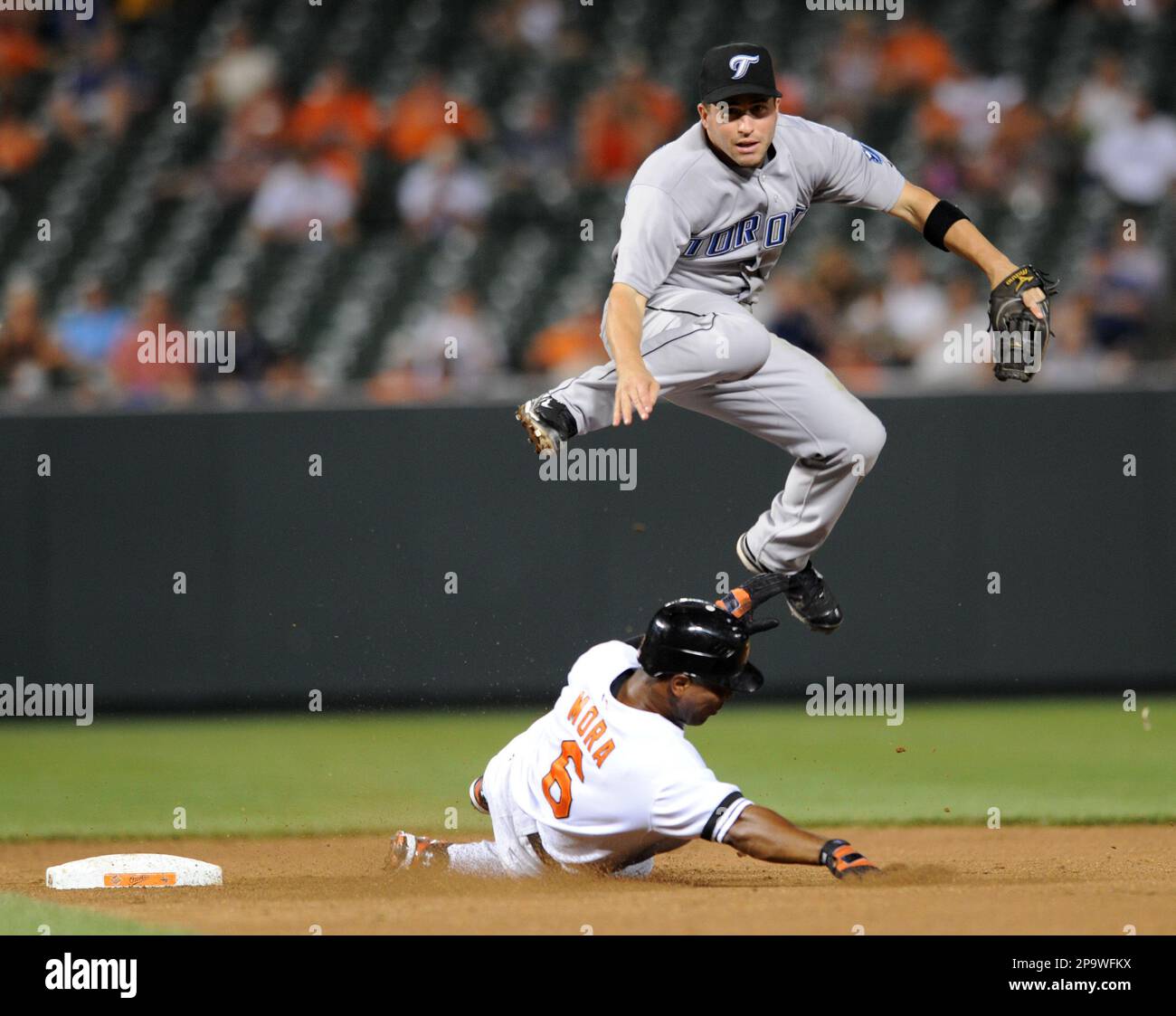Baltimore Orioles Melvin Mora slides under Toronto Blue Jays shortstop John McDonald as he turns a double play on a ground ball hit by Luke Scott in the seventh inning of a baseball game Tuesday, July 22, 2008 in Baltimore. The Blue Jays won 10-8. (AP Photo/Gail Burton) Foto Stock