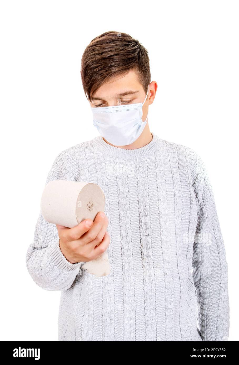 Uomo giovane triste in maschera di influenza con un foglio di carta igienica isolato sullo sfondo bianco Foto Stock