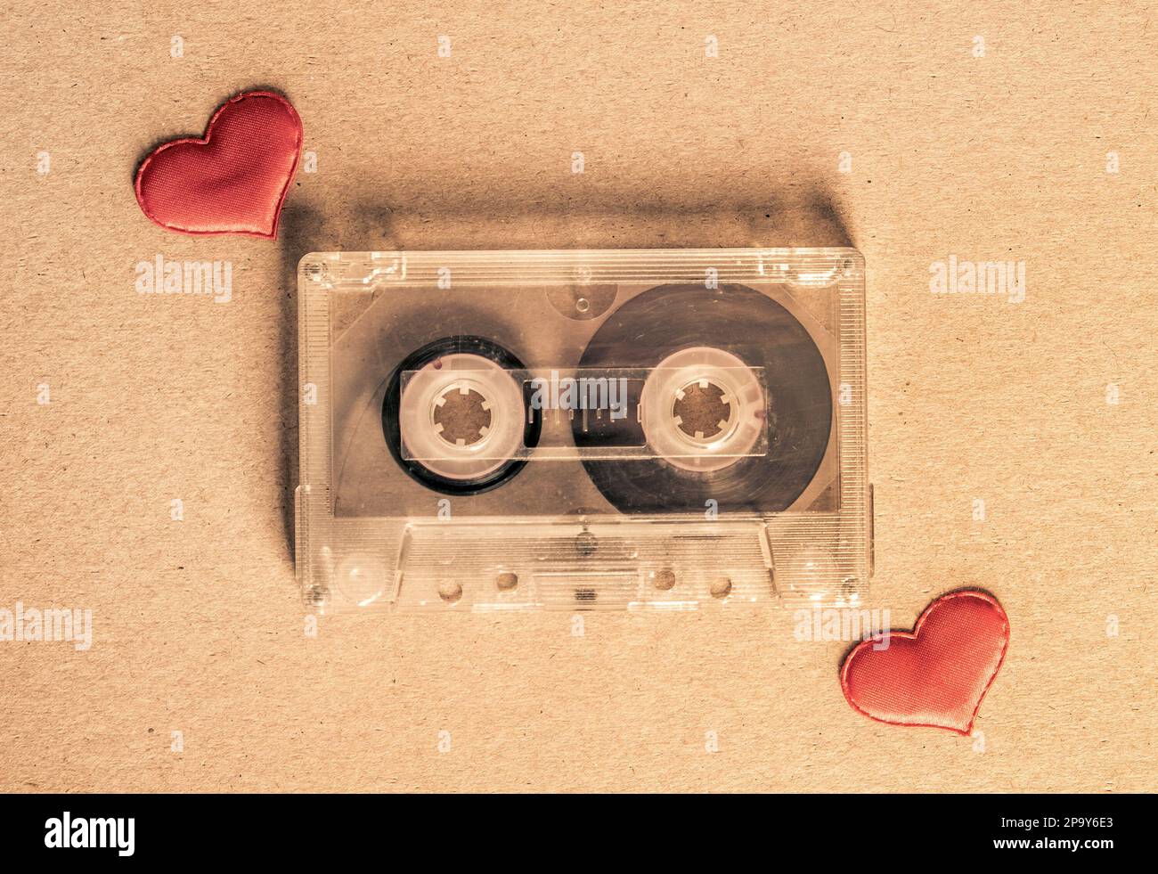 Foto dai toni della vecchia cassetta audio con un cuore rosso sul primo piano della carta Foto Stock