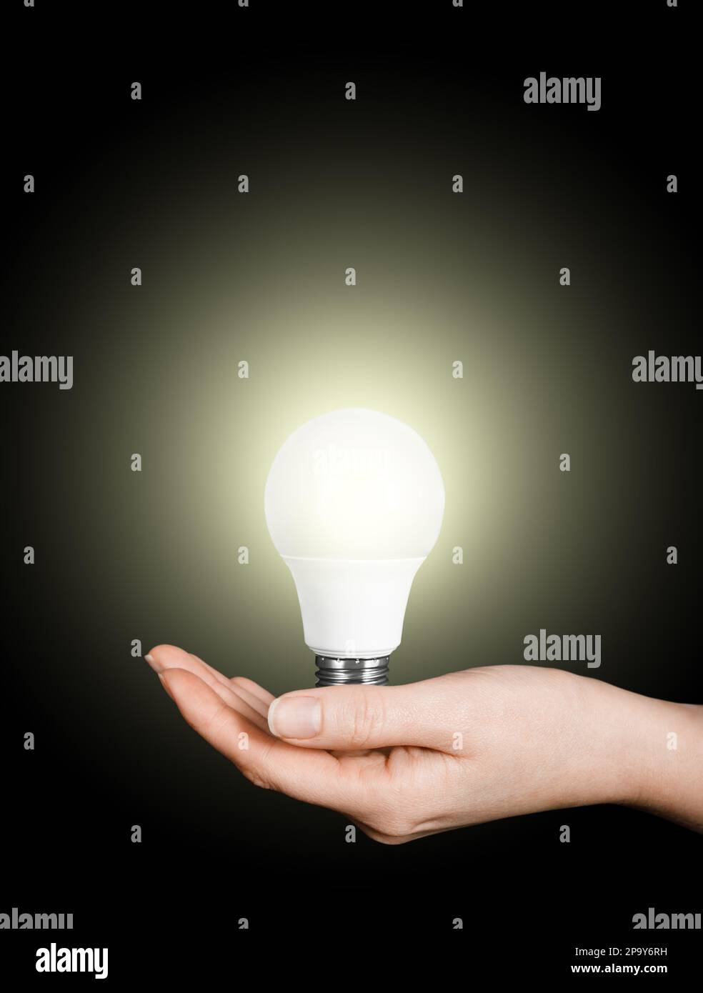 lampada a led da donna su sfondo nero, concetto di energia Foto Stock