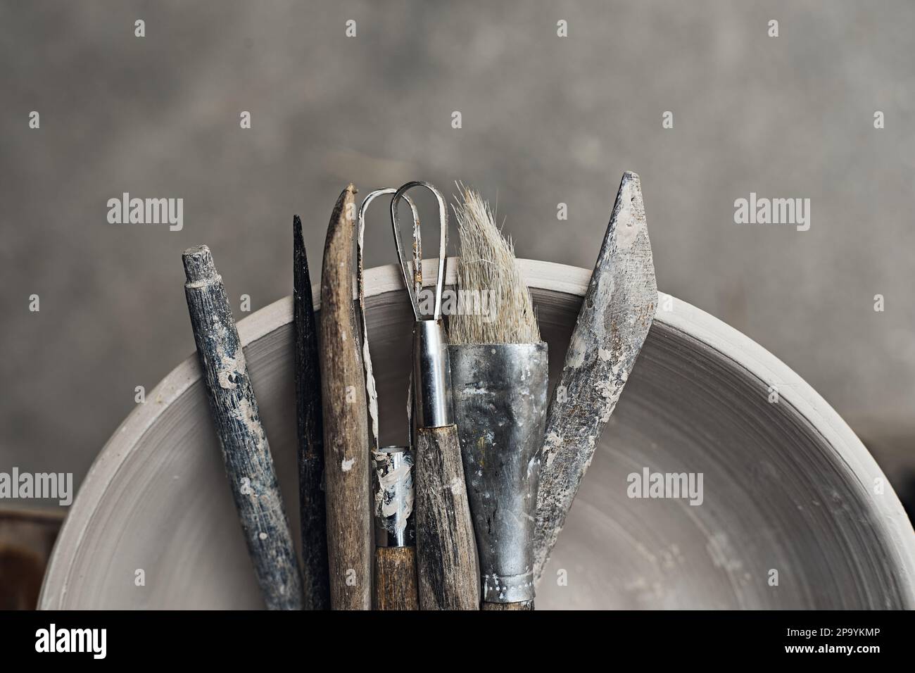 Strumenti per formare argilla con pentole in background, fuoco selettivo Foto Stock