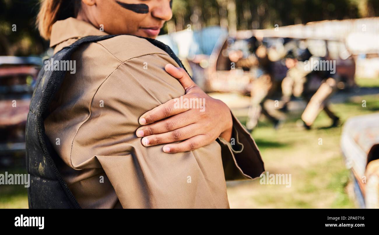 Lesioni alle mani, ai soldati e alle braccia durante lo sport del paintball, la corsa o l'addestramento militare da una battaglia intensa o da una guerra sul campo d'erba. Mano di donna esercito sportivo Foto Stock