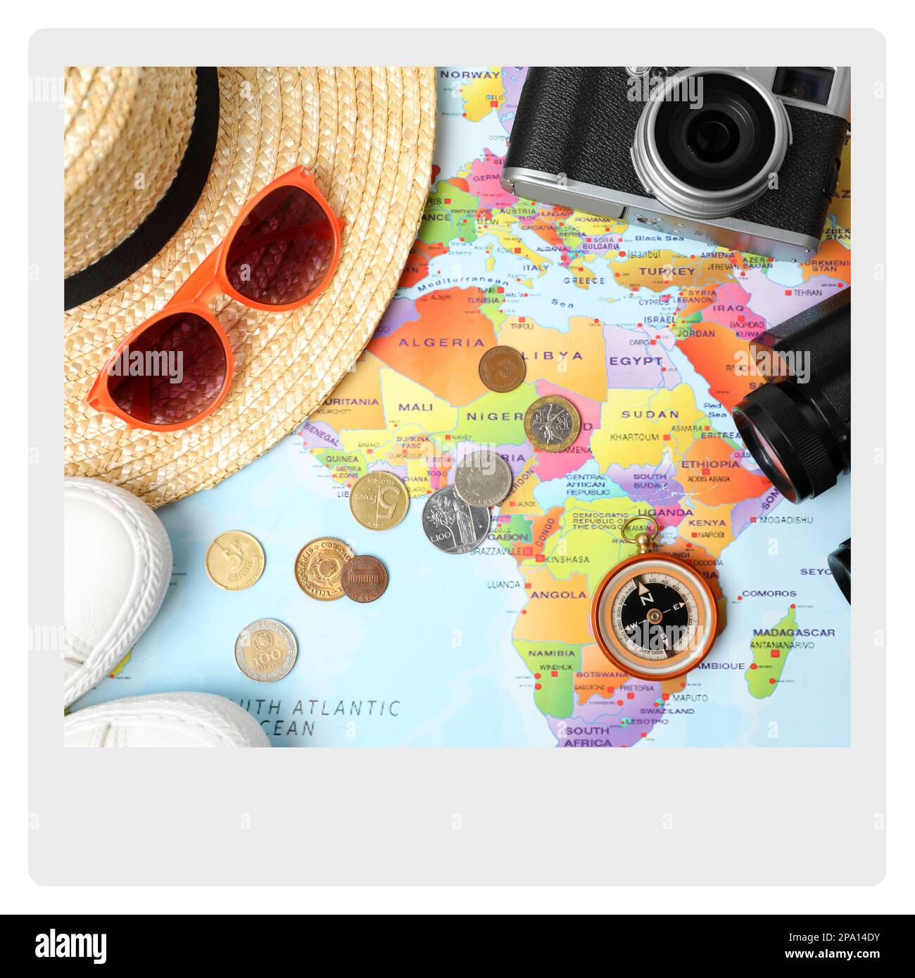 Carta fotografica. Composizione piana con diversi accessori da viaggio sulla mappa del mondo Foto Stock