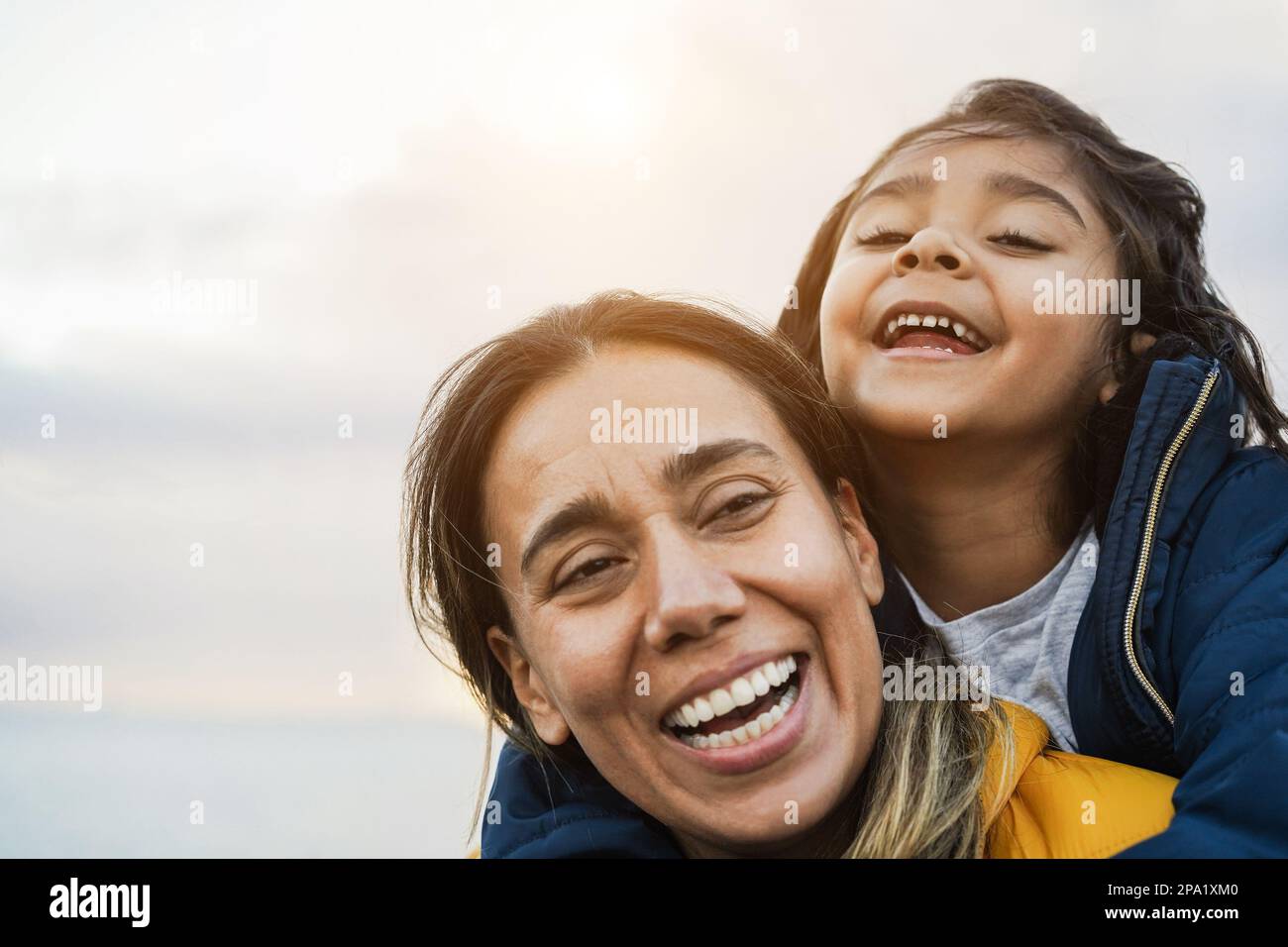 Felice madre latina e figlia divertirsi durante il periodo invernale - Focus principale sulla bocca della ragazza Foto Stock