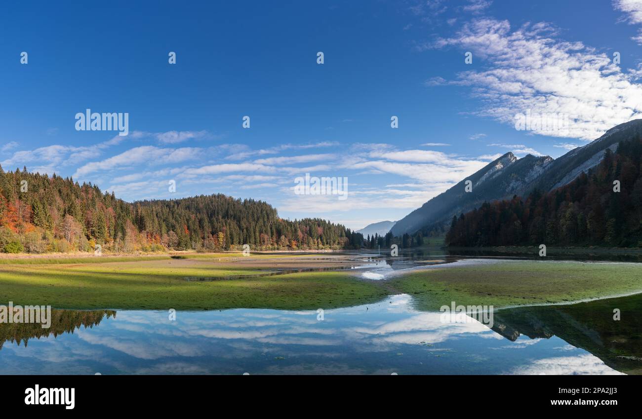 Paesaggio di montagna di colore autunnale e lago nelle Alpi svizzere con foreste e riflessi Foto Stock