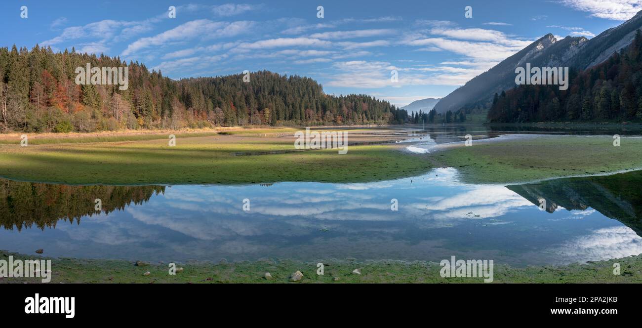 Paesaggio di montagna di colore autunnale e lago nelle Alpi svizzere con riflessi e foreste Foto Stock