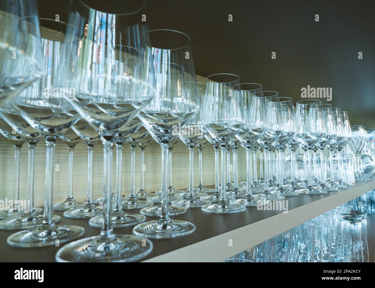 Fila infinita di bicchieri da vino impilati su una mensola di legno in un bar ristorante Foto Stock