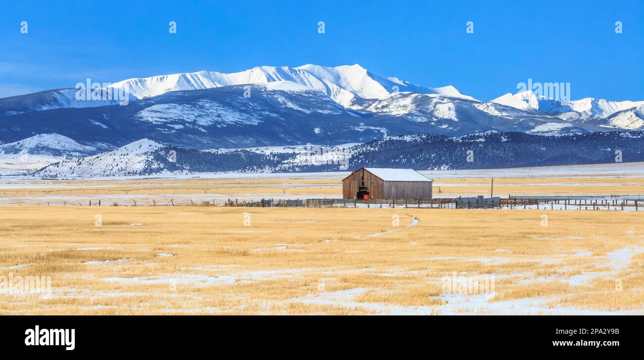 panorama di un fienile e campi di fattoria sotto il monte haggin in inverno vicino ad anaconda, montana Foto Stock