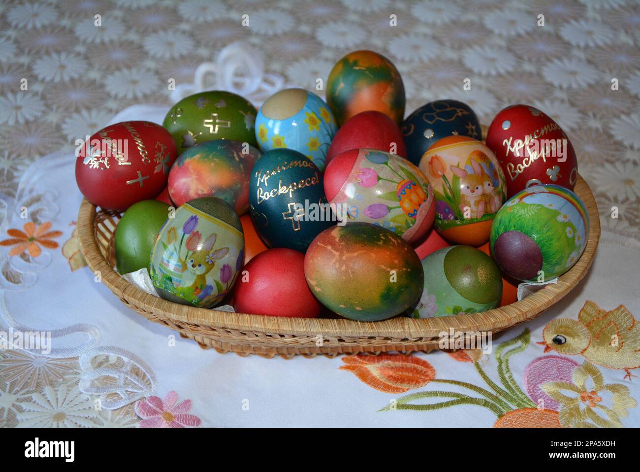 Primo piano di un cesto di tessitura con uova colorate multicolore per la tradizionale celebrazione pasquale in Bulgaria in aprile. Immagine orizzontale, messa a fuoco selettiva Foto Stock