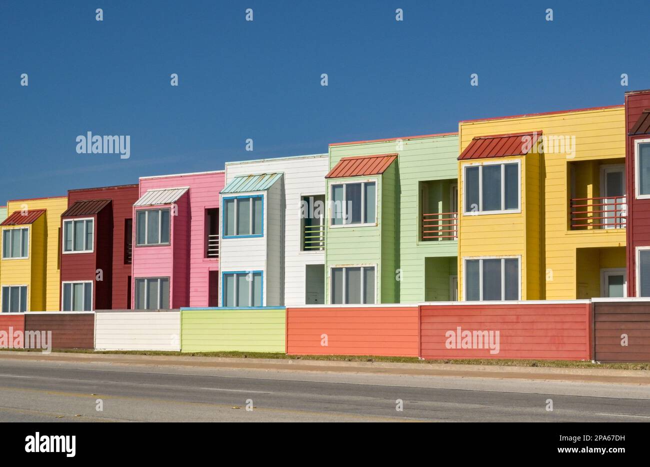 Galveston, Texas, USA - Febbraio 2023: Fila di appartamenti di vacanza dai colori vivaci in tonalità pastello sul lungomare di Galveston Foto Stock