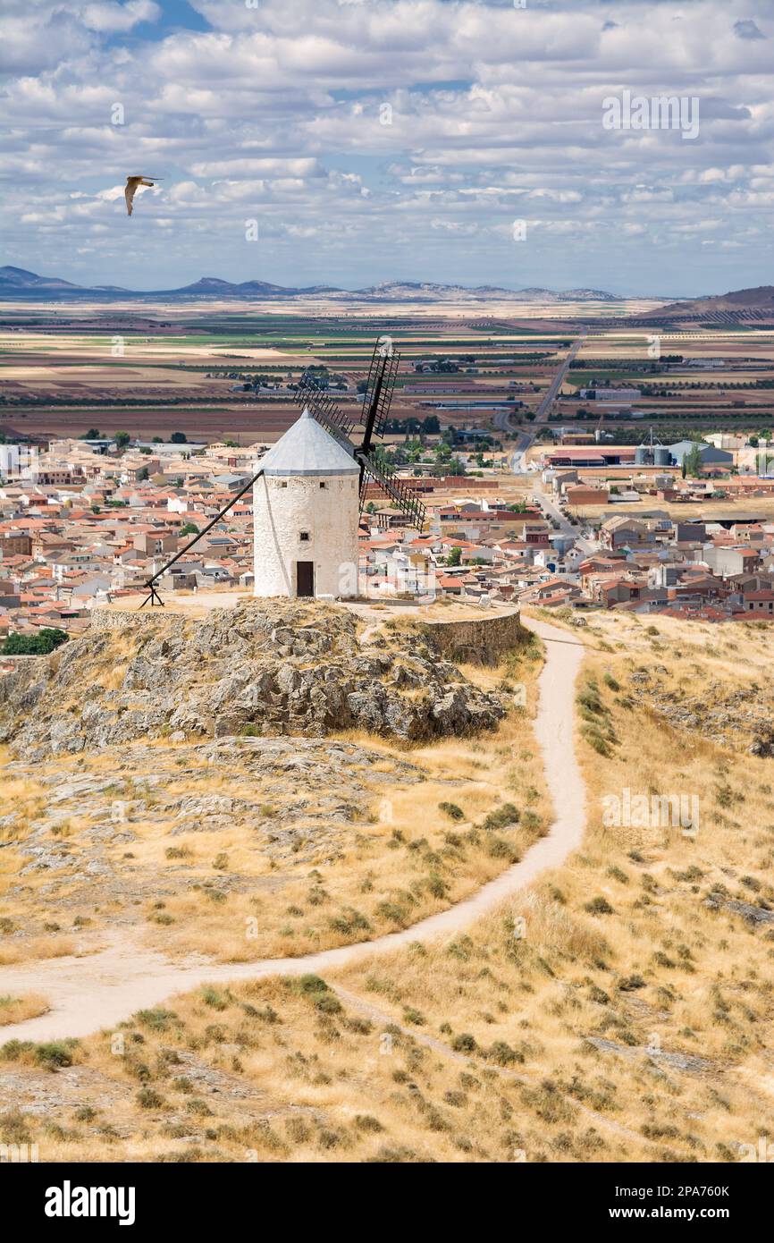 Mulino a vento sulla collina e sullo sfondo il villaggio di Consuegra, Spagna Foto Stock