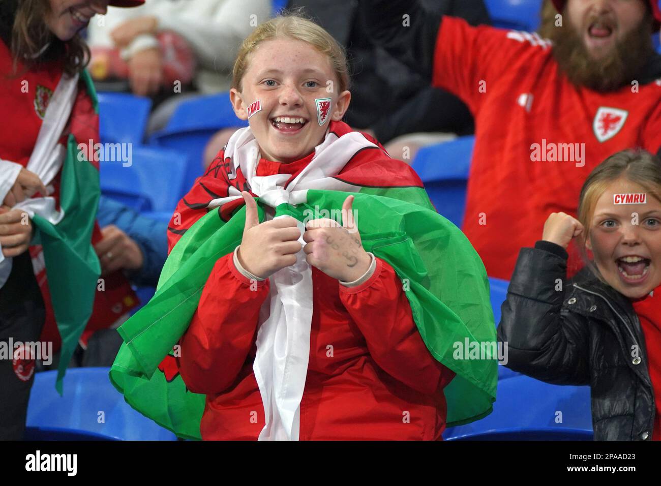 Tifosi gallesi al Cardiff City Stadium, una giovane tifosa drappeggiata da una bandiera gallese Foto Stock