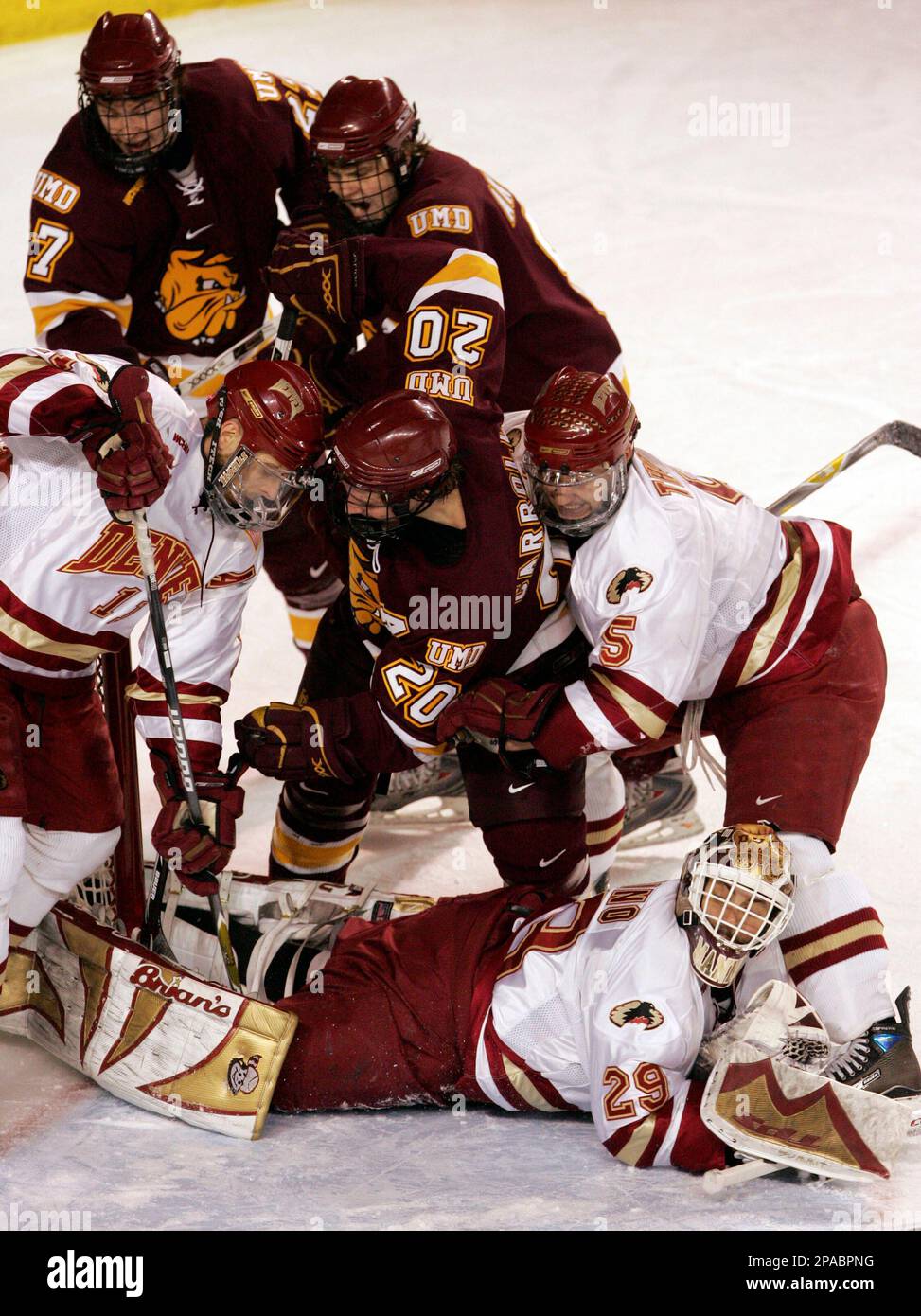 Minnesota Duluth left winger Andrew Carroll (20) scores a goal as Denver defenseman J.P. Testwuide (11) and Andrew Thomas (5) and goalie Peter Mannino (29) try and defend while Minnesota Duluth right winger Mike Curry (27) and Drew Akins, back, look on during the second period of an NCAA hockey game in Denver, Friday, March 14, 2008. (AP Photo/Jack Dempsey) Foto Stock