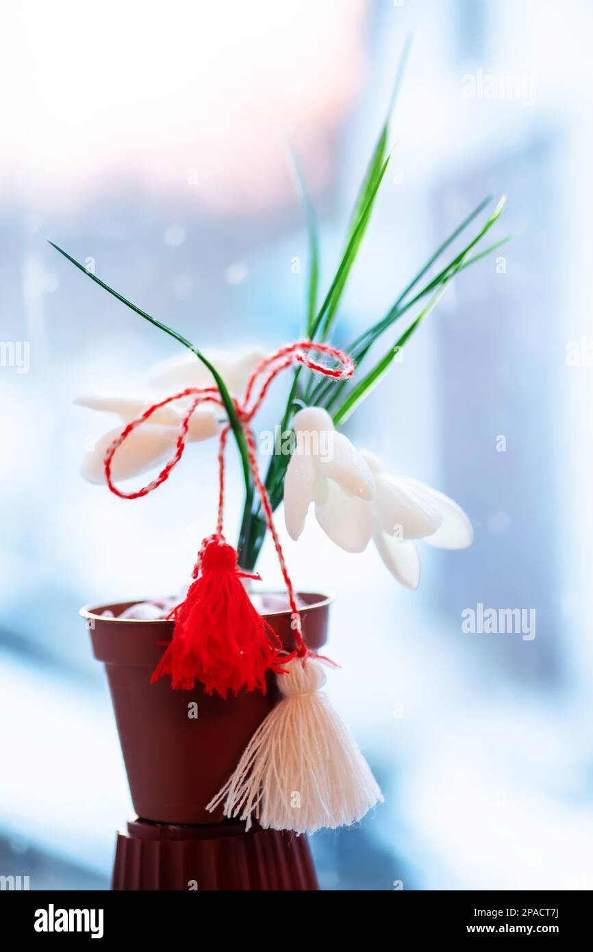 Simbolo della primavera e delle vacanze di Baba Marta in Bulgaria, Romania e Moldavia. Accessorio tradizionale martisor, un rosso e bianco buona fortuna fascino su un Foto Stock