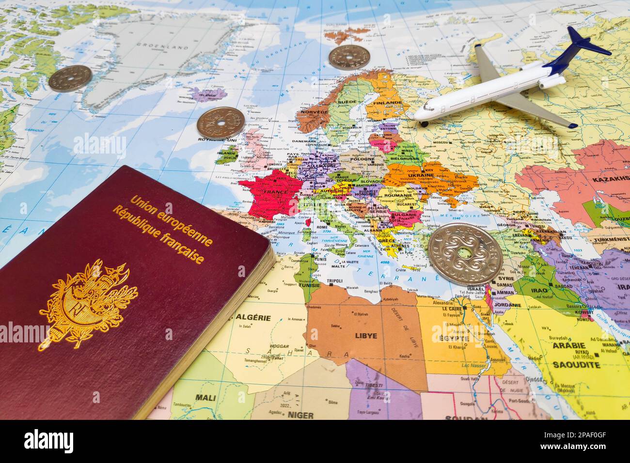 Copenaghen, Danimarca - febbraio 19 2019: Composizione composta da una mappa mondiale incentrata sull'Europa con su di essa, alcune monete danesi in corona e un passp francese Foto Stock