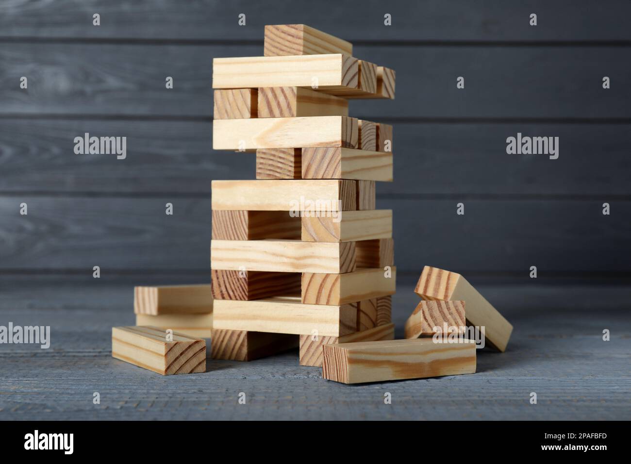 Jenga torre e blocchi di legno su tavolo grigio. Gioco da tavolo Foto stock  - Alamy