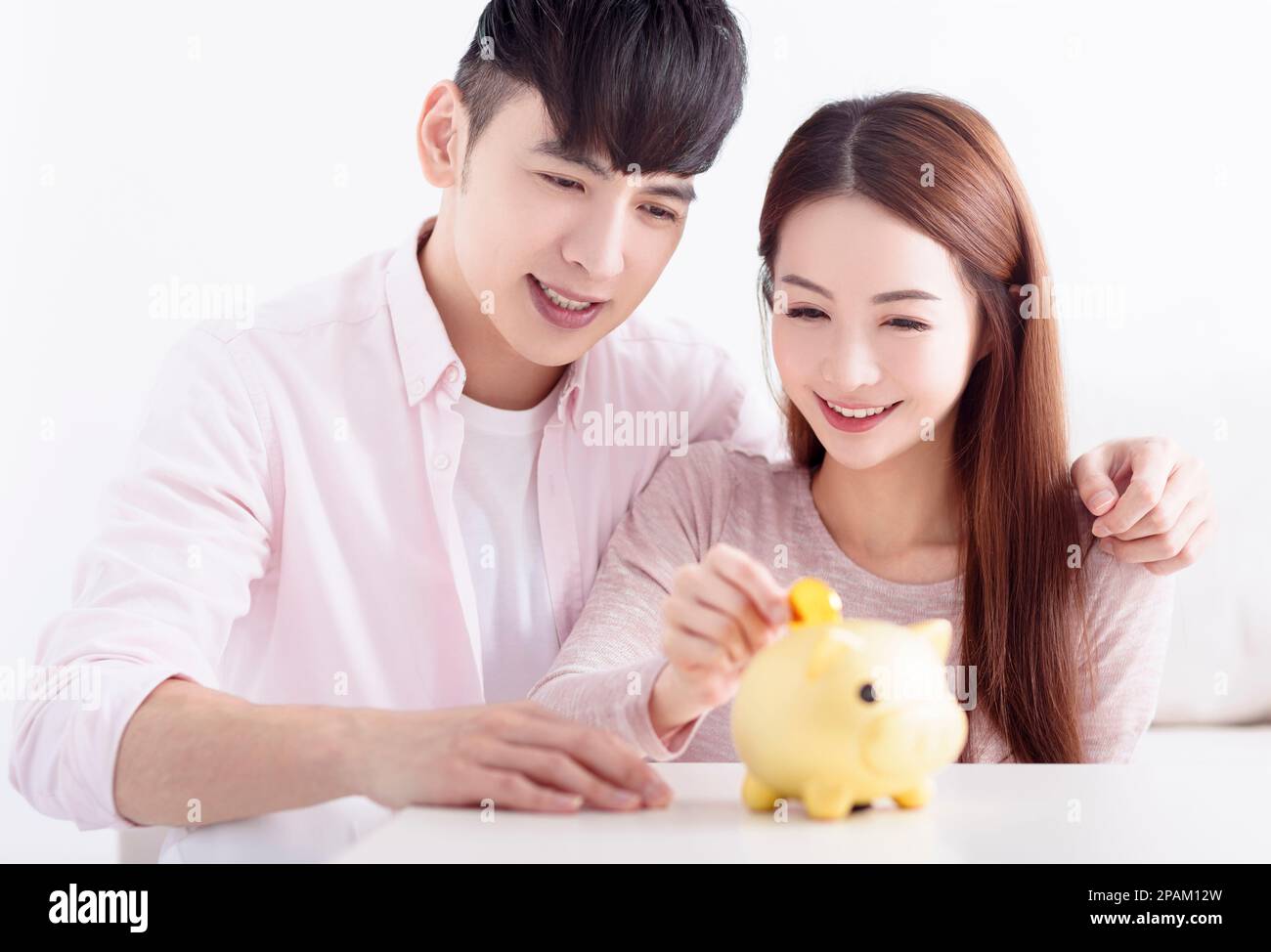 Giovane coppia asiatica che tiene Piggybank e fare risparmi per il futuro Foto Stock