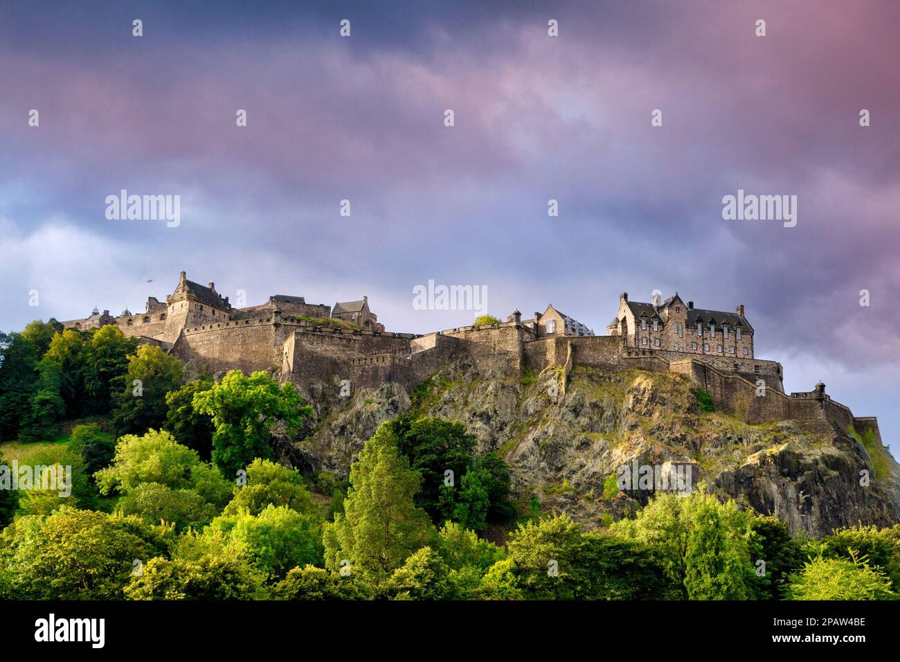Castello di Edimburgo, arroccato sulla sua roccia sopra gli alberi su Princes Street Gardens. Foto Stock