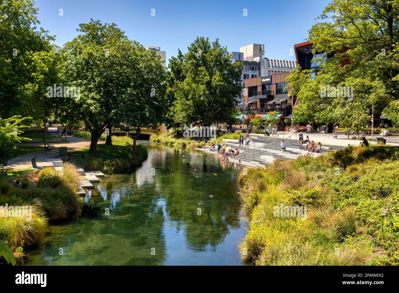 31 dicembre 2022: Christchurch, Nuova Zelanda - persone che si godono una giornata estiva al Terrace, un nuovo sviluppo lungo il fiume, seduti sui gradini vicino al ri Foto Stock