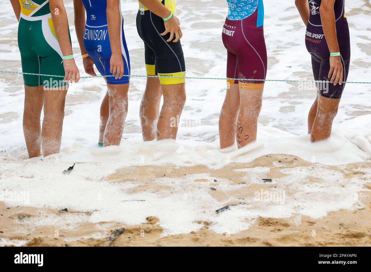 Concorrenti in piedi in acqua in attesa dell'inizio delle Scuole nazionali Triathlon a Hervey Bay, Esplanade, Torquay, Queensland, Australia Foto Stock