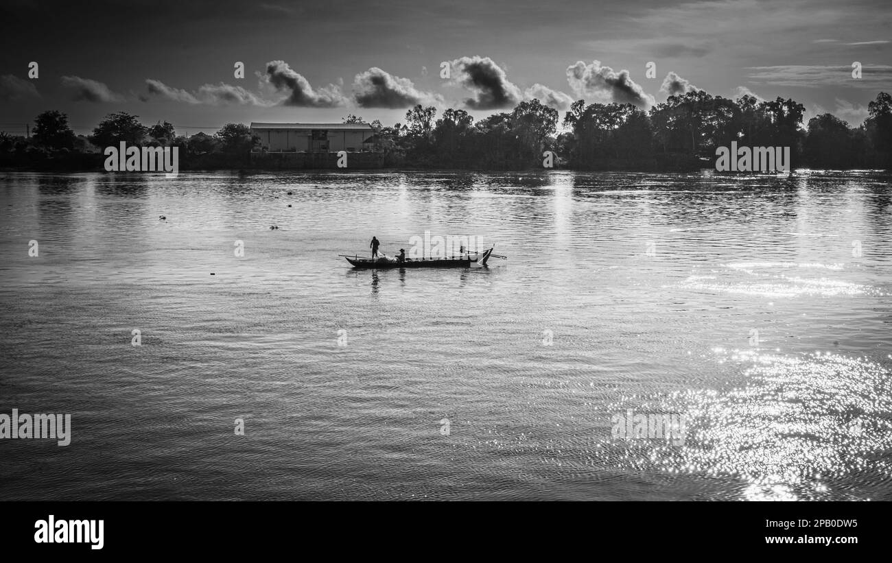 Due pescatori che lavorano sulla loro piccola imbarcazione tradizionale di legno sul fiume Mekong nella provincia di Kandal, Cambogia. Foto Stock