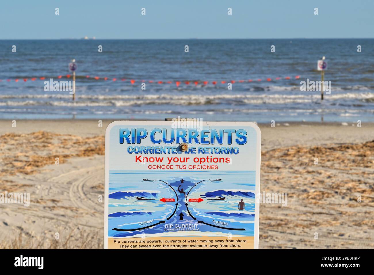 Galveston, Texas, USA - Febbraio 2023: Cartello di avvertimento che informa i visitatori della spiaggia sul pericolo di correnti di lacerazione nel mare Foto Stock