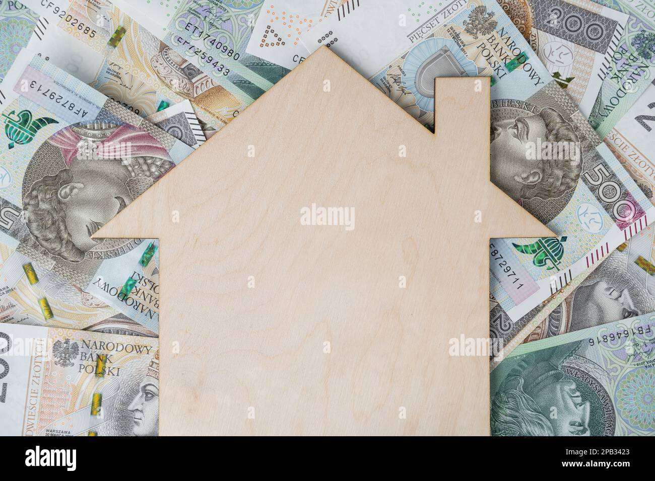 Ipoteca o concetto di prestito con spazio di copia. Denaro polacco złoty, banconote PLN zloty e casa modello in legno. Acquistare una casa, un appartamento o un appartamento in Polonia. Foto Stock