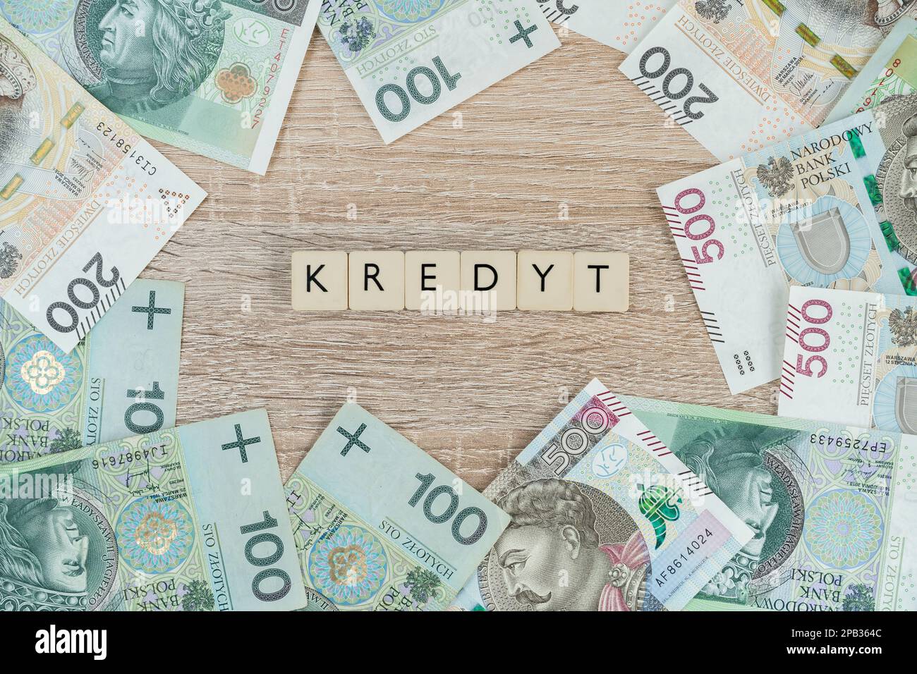 La parola kredyt in lingua polacca significa prestito o mutuo. Comprare una casa o un appartamento in Polonia. Composizione flat lay con banconote in zloty PLN. Foto Stock