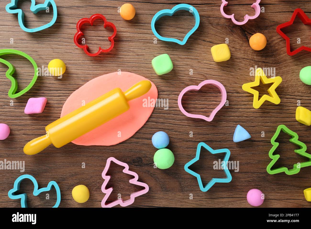 Pasta di colore diverso gioco con stampi su tavolo di legno, piatto Foto Stock