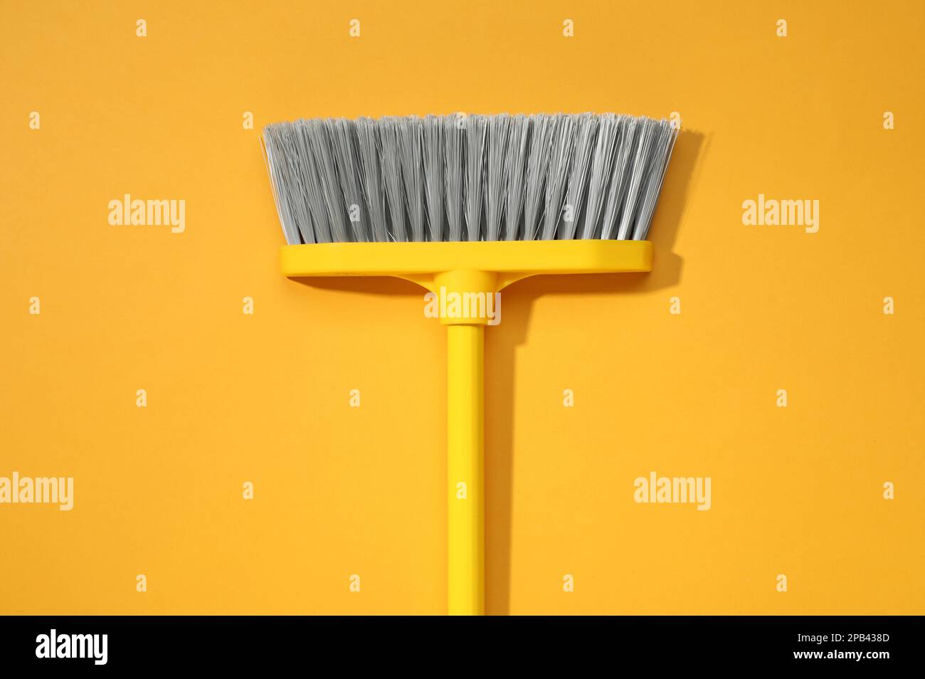 Scopa in plastica su sfondo giallo, vista dall'alto Foto Stock