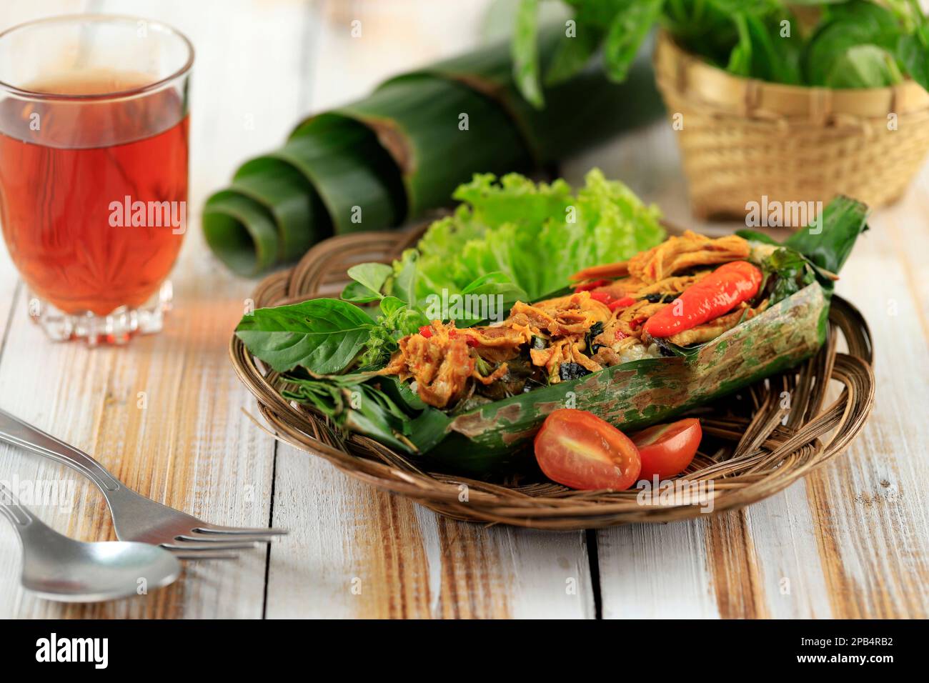 Nasi Bakar Ayam Kemangi, riso al vapore con pollo tritato piccante Stir Fry e foglia di basilico dolce, impacco con foglia di banana e grigliato Foto Stock