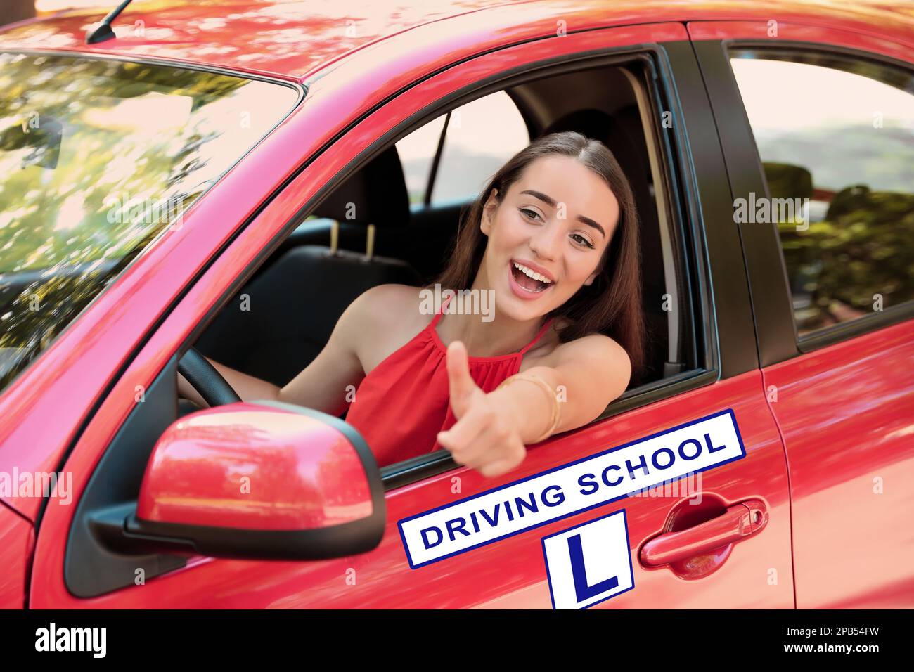 Felice giovane donna in auto. Scuola guida in visita Foto Stock