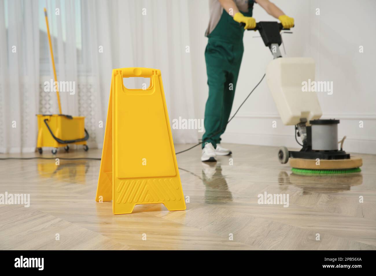 Janitor professionale per la pulizia di pavimenti in parquet con lucidatrice  interna, primo piano Foto stock - Alamy