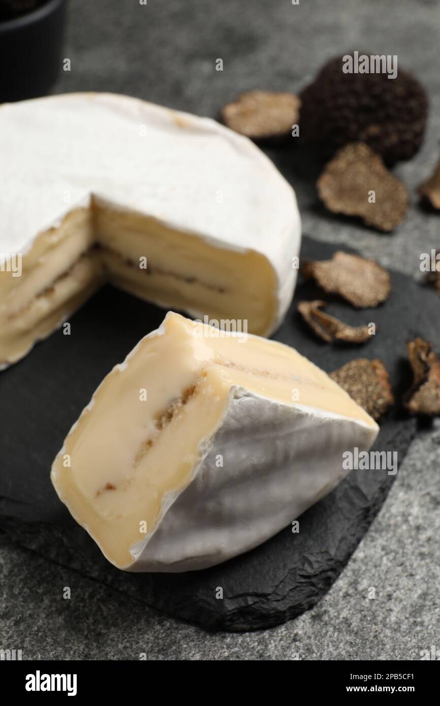 Delizioso formaggio al tartufo su tavola grigia, primo piano Foto Stock