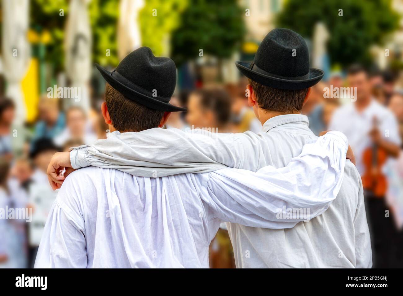 Ragazzi danzanti folcloristici in camicie e cappelli bianchi Foto Stock