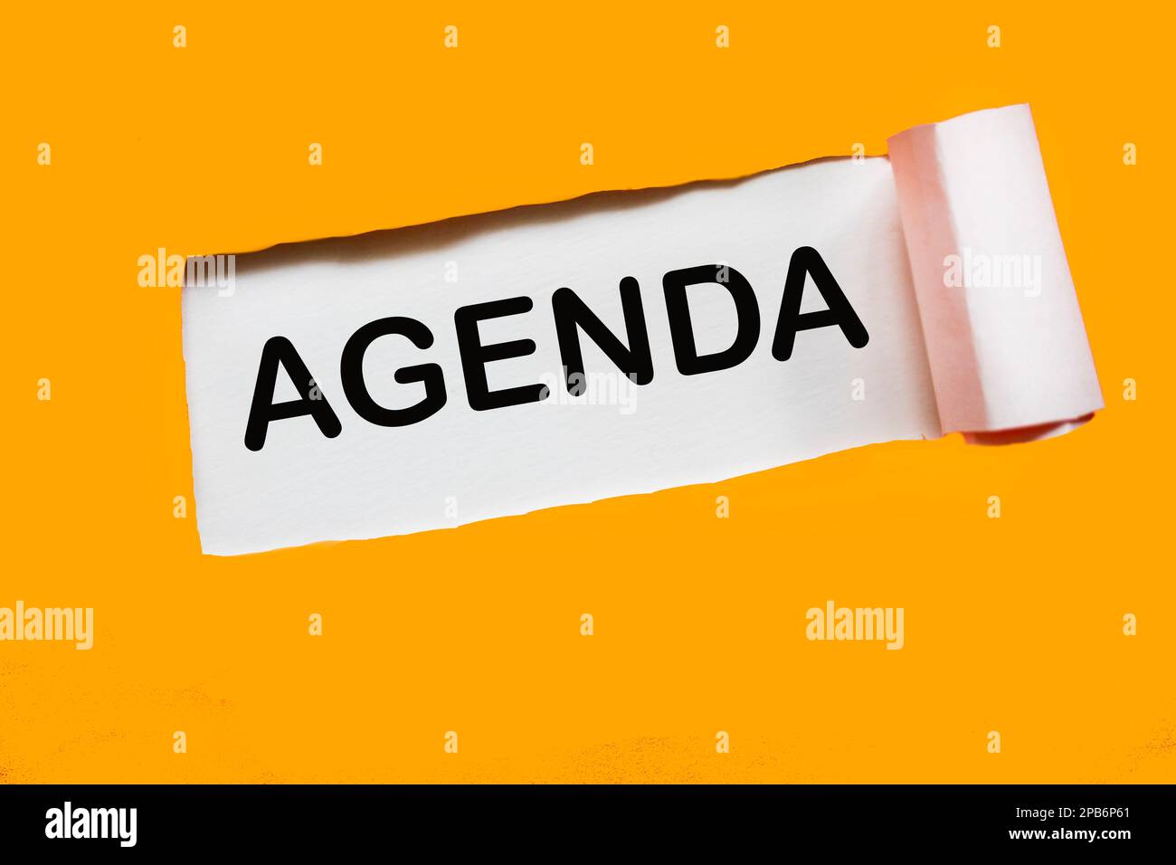 Simbolo dell'azienda e dell'agenda. Il concetto di Agenda si cela dietro un Libro bianco lacerato. Bellissimo sfondo giallo, spazio copia. Affari e programma concep Foto Stock