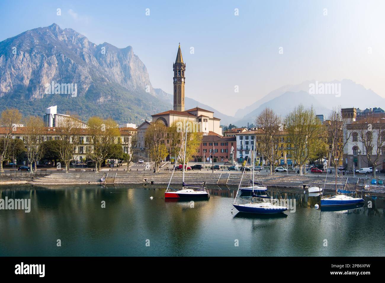 Il giorno di primavera, l'alba aerea nebbiosa del paesaggio urbano di Lecco. Pittoresco lungomare della città di Lecco situato tra il famoso Lago di Como e la scenografica Bergamo A. Foto Stock