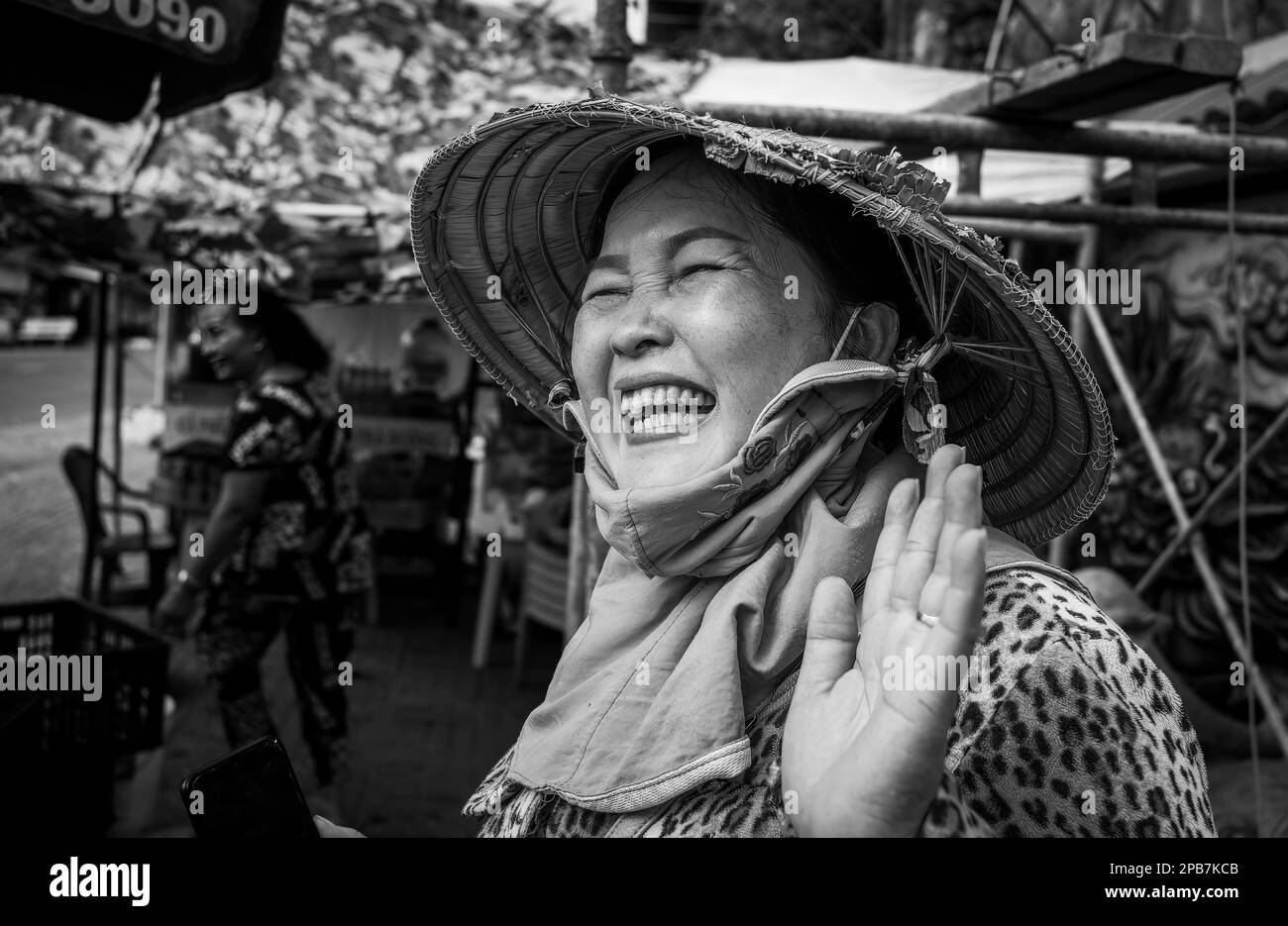 Una donna vietnamita che indossa un tradizionale cappello conico sorride e si posa per una foto a Tan Chau nel Delta del Mekong in Vietnam. Foto Stock