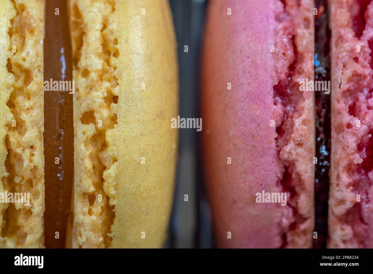 Dettaglio primo piano dei macaron ripieni di giallo e rosa Foto Stock