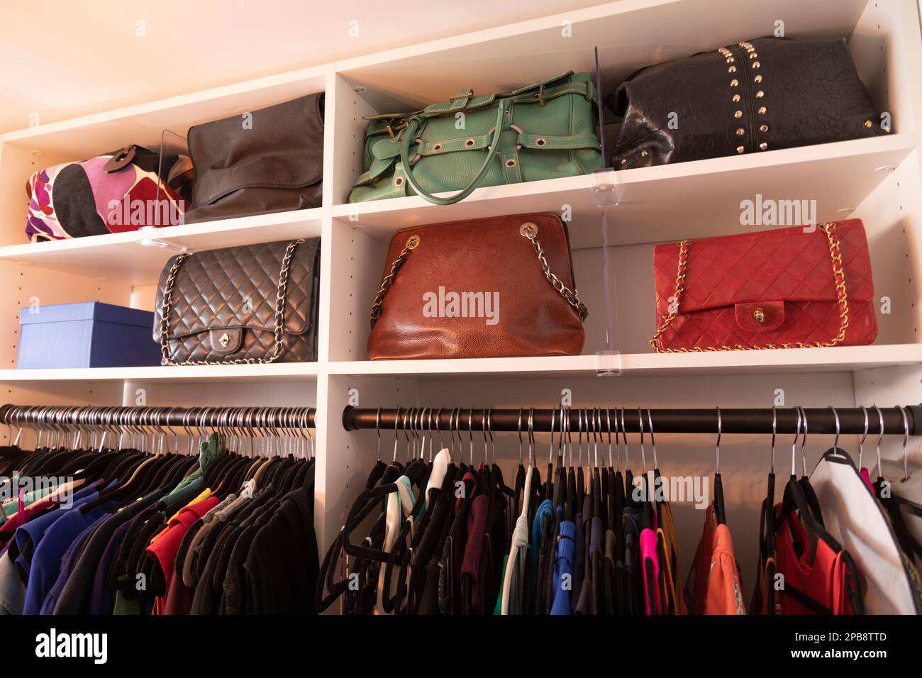 armadio a muro con borse e abiti di lusso su una rastrelliera Foto Stock