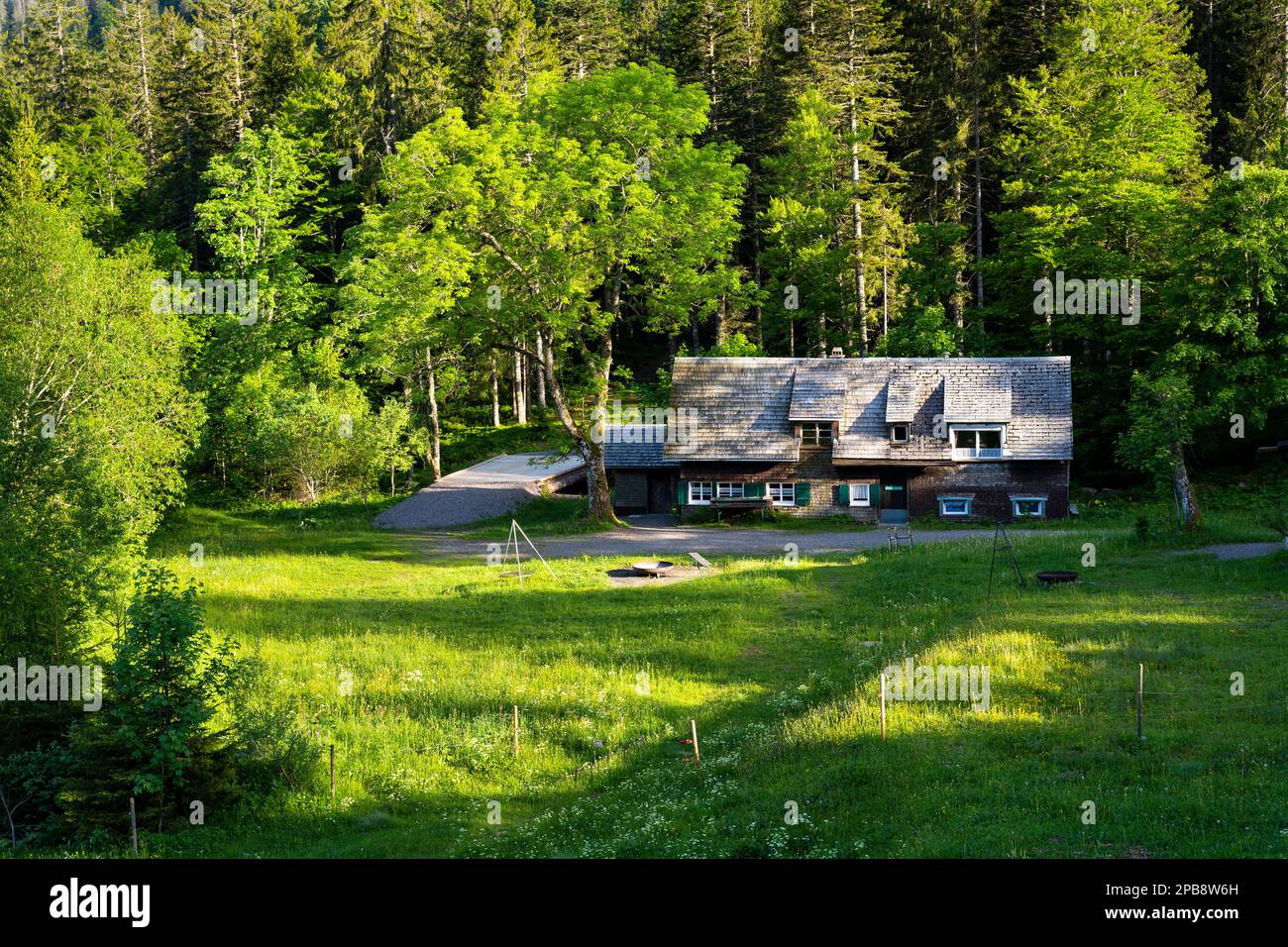 Una tipica casa in legno nella Foresta Nera con persiane verdi e un tetto in legno. Immagine presa da un terreno pubblico. Foto Stock