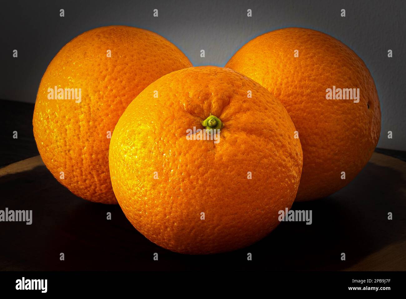 Arance fresche e profumate su un piedistallo di legno. Tre frutti pieni di vitamina C per la salute. Foto Stock