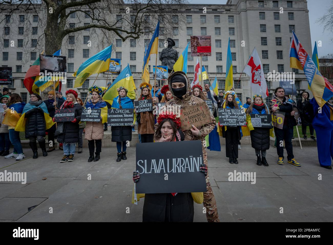 Londra, Regno Unito. 11th marzo 2023. Attivisti e sostenitori britannico-ucraini svolgono un'azione di protesta a Westminster contro l'invasione russa in corso e i crimini di guerra in Ucraina. In un recente video caricato sul telegramma presumibilmente dai soldati russi, un prigioniero di guerra ucraino, disarmato, viene girato più volte dai suoi prigionieri russi poco dopo aver detto: “Gloria per l’Ucraina”. Egli schiompe morto a terra. Il video ha condotto a un'indagine sui crimini di guerra e, all'interno dell'Ucraina, a una battaglia sull'identità di un uomo acclamato come eroe nazionale e simbolo di resistenza. Credit: Guy Corbishley/Alamy Live News Foto Stock