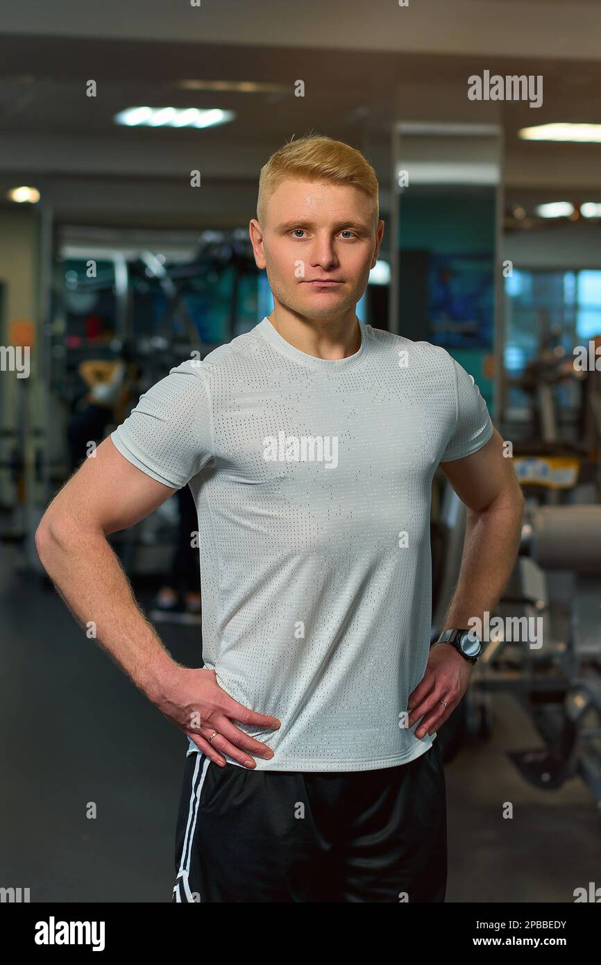 il ragazzo biondo si sta allenando in palestra Foto Stock