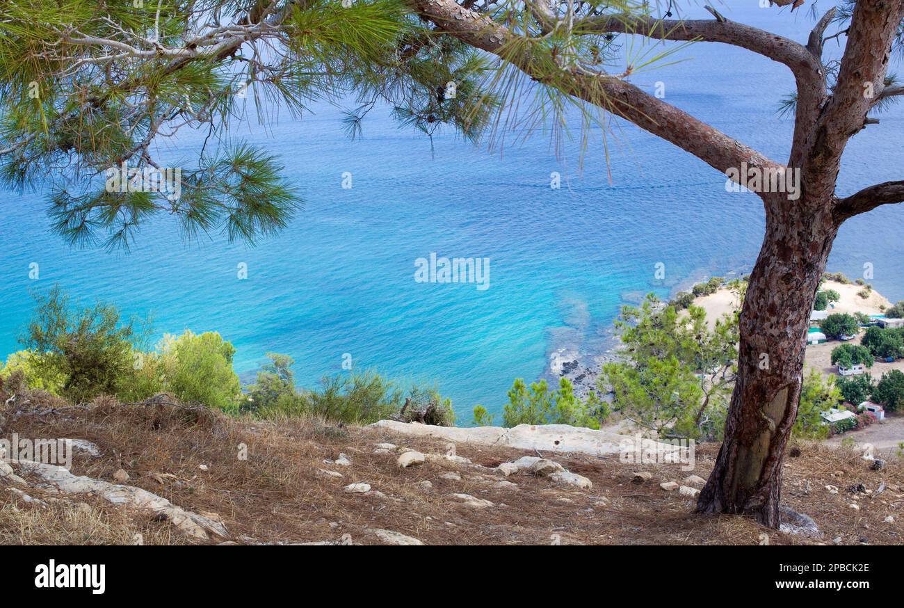 Qualche tipo di campeggio con auto con rimorchi (campo selvaggio?) Nell'angolo in basso a destra e una bellissima spiaggia di Cipro e il Mar Mediterraneo e le nuvole Foto Stock